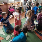 Dziewczynka prezentuje kubek z suchym lodem innym przedszkolakom