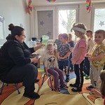 Dzieci oglądają eksperymenty z suchym lodem prezentowane przez prowadzącą