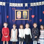 Dziewczynki ubrane odświętnie na tle dekoracji z okazji Dnia Babci i Dziadka