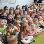 Przedszkolaki siedzą na dywanie  i czekają na przedstawienie