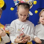 Dziewczynka trzyma małą maskotkę w kształcie pszczółki 