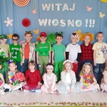 Przebrane dzieci z grupy Biedronki na tle wiosennej dekoracji