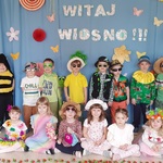 Przebrane dzieci z grupy Motylki na tle wiosennej dekoracji