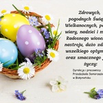 kartka z kolorowymi pisankami, w tle koszyczek Wielkanocny z życzeniami Wielkanocnymi