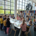 Przedszkolaki oglądają literaturę dziecięcą w czytelni