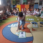 Dziewczynka dopasowuje emblemat z obrazkiem do odpowiedniego pojemnika na śmieci