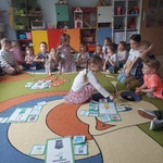 Dziewczynka dopasowuje emblemat z obrazkiem do odpowiedniego pojemnika na śmieci