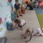 Dzieci w konkurencji zamiatania kolorowych kólek z kartek do bramek