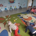 Dzieci w konkurencji zamiatania kolorowych kólek z kartek do bramek