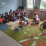 Dzieci w konkurencji zamiatania kolorowych kólek z kartek do bramek