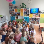 Dzieci siedzące na dywanie, oglądające film edukacyjny o ekologii 
