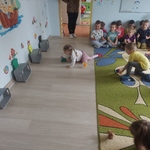Dzieci w konkurencji zamiatania kolorowych kólek z kartek do bramek