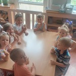 Pszczółki siedzące przy stolikach jedzące lody