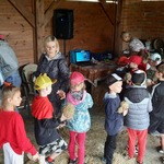 Dzieci z pomocą prowadzącej i nauczycielek łączą przygotowane elementy ptaka z siana