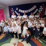 Dzieci z nauczycielkami na tle dekoracji z okazji Święta